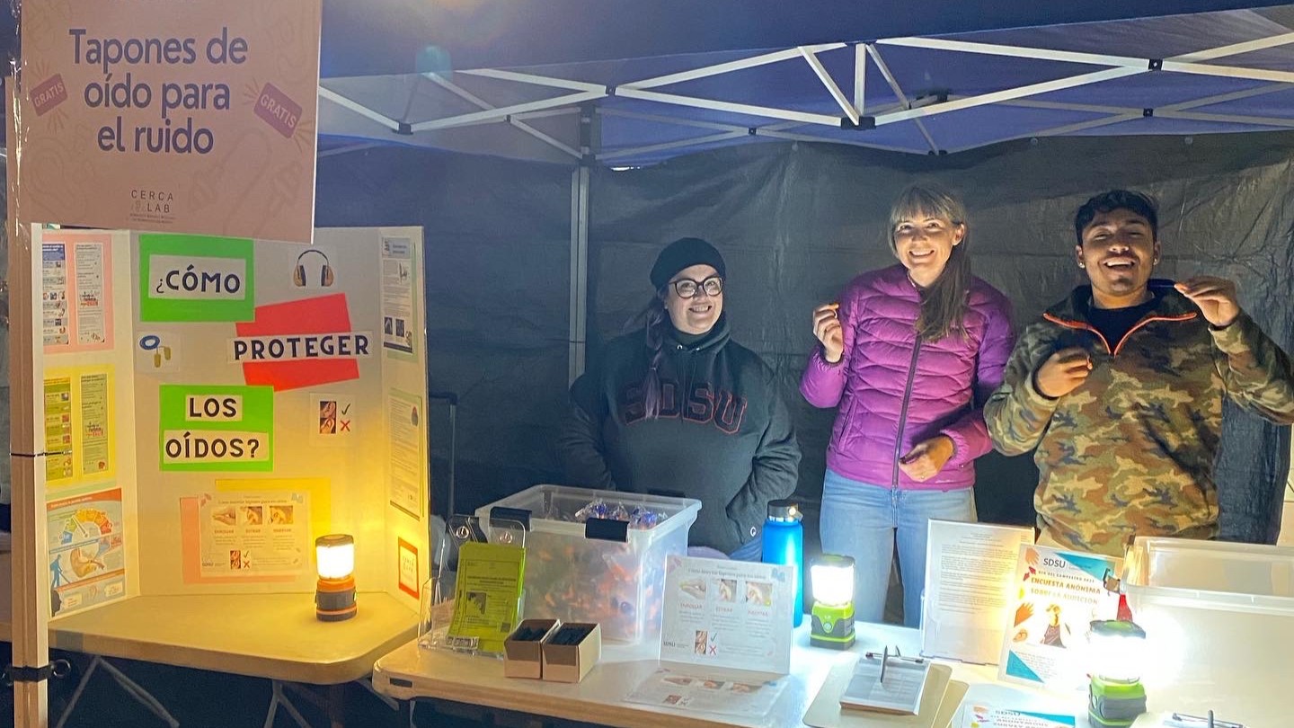 Dr Coco with lab students at a booth in Mexico